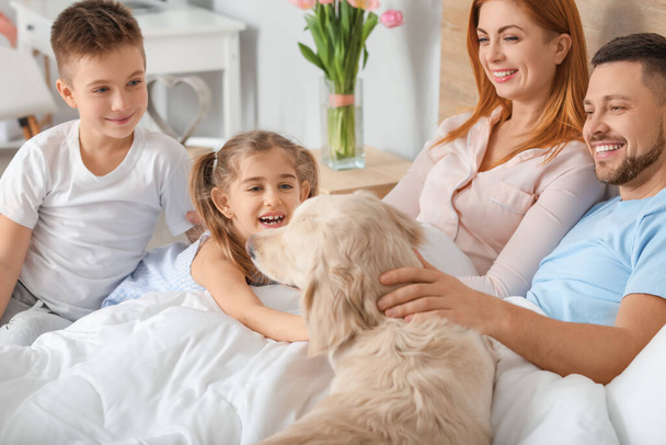 Ευτυχισμένη οικογένεια με σκύλο στην κρεβατοκάμαρα στο σπίτι - Φωτογραφία, εικόνα