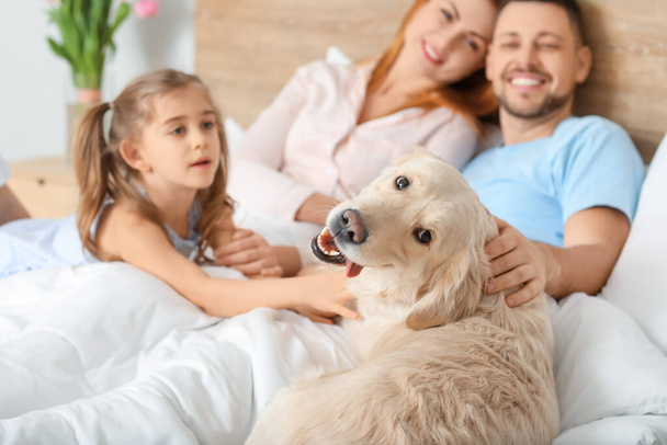Ευτυχισμένη οικογένεια με σκύλο στην κρεβατοκάμαρα στο σπίτι - Φωτογραφία, εικόνα
