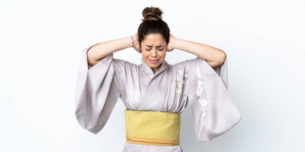 Frau trägt Kimono über isoliertem Hintergrund frustriert und verdeckt Ohren - Foto, Bild