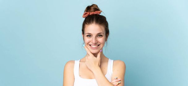 Young caucasian woman isolated on blue background happy and smiling - Фото, изображение