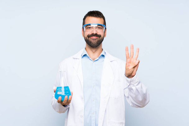 Nuori tieteellinen tilalla laboratorio pullo yli eristetty tausta onnellinen ja laskenta kolme sormin
 - Valokuva, kuva