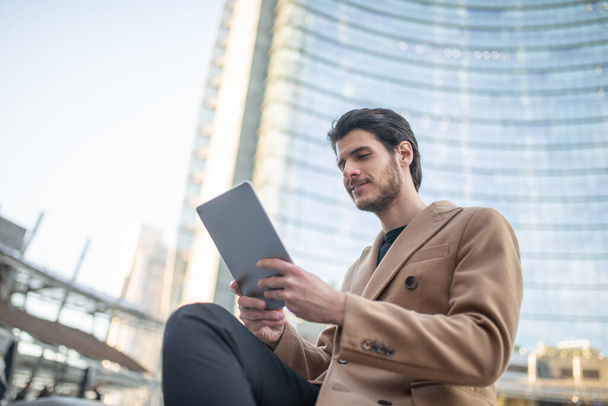 Young man using his tablet outdoor in a city - Foto, immagini