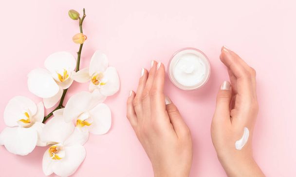 Woman applying moisturizing cream on hands. Cosmetic cream lotion concept. - Foto, imagen