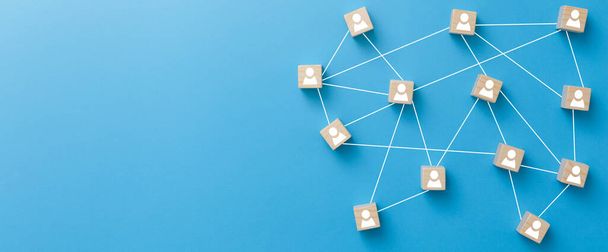Wooden blocks connected together on blue background. Teamwork, network and community concept. - Foto, Imagem