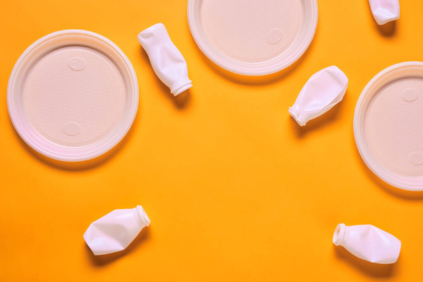 Horizontal plana composição leigos de plástico branco placas vazias e garrafas no fundo laranja, espaço de cópia
 - Foto, Imagem