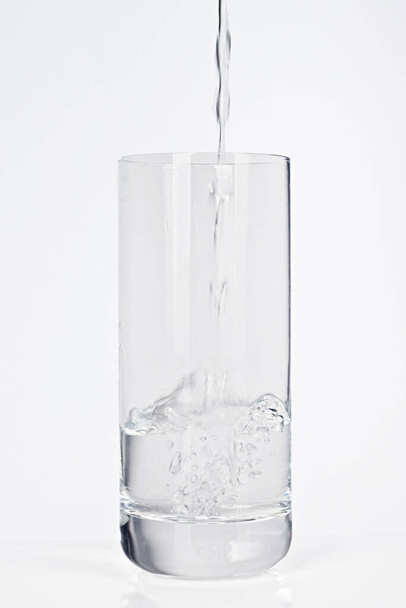 Pour mineral water into a glass - Foto, afbeelding