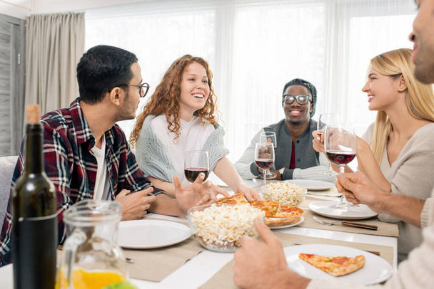 Gruppo multietnico di cinque amici che si rilassano a cena insieme a tavola nel fine settimana, colpo orizzontale
 - Foto, immagini