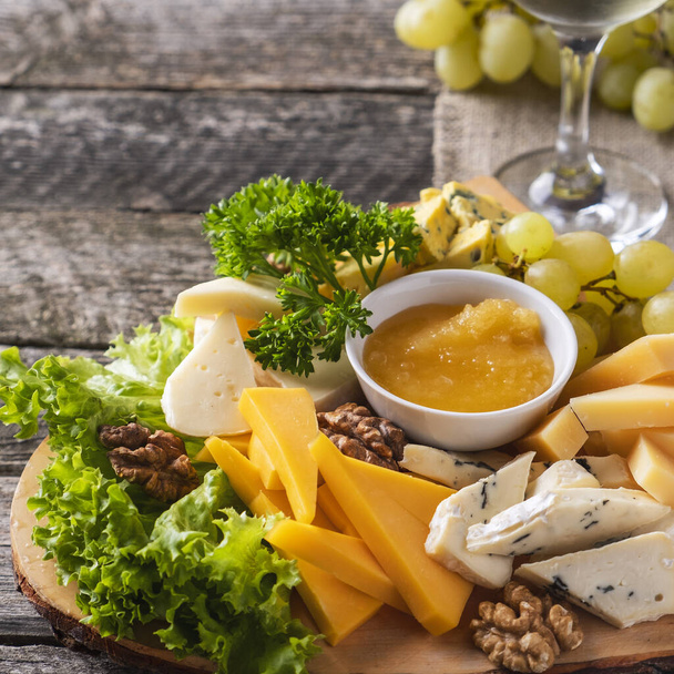 Assorted cheeses. Cheese plate on a wooden board. Closeup - Photo, Image