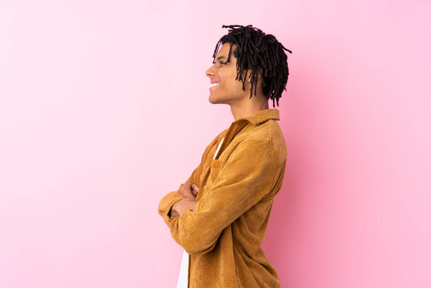 Young African American man with corduroy jacket over isolated pink background in lateral position - Photo, Image