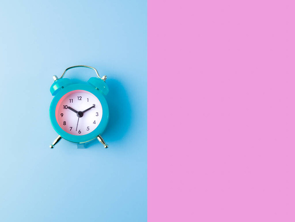 pequeno relógio de alarme clássico azul isolado em meio pastel rosa e fundo azul pastel, acordar conceito, com espaço de cópia
 - Foto, Imagem