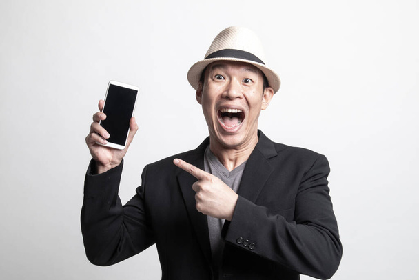 Excited  Adult Asian man point to mobile phone on white background - 写真・画像