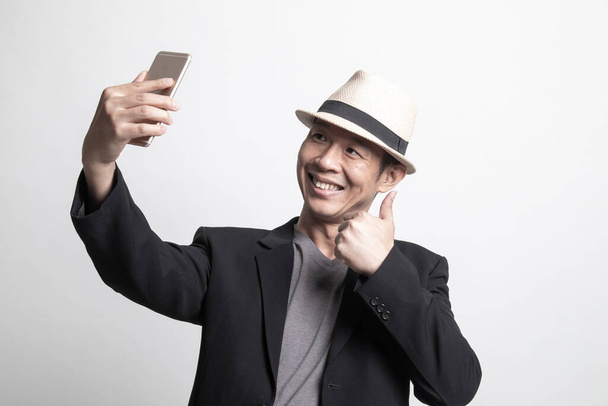 Young Adult Asian man  selfie with mobile phone on white background - Valokuva, kuva