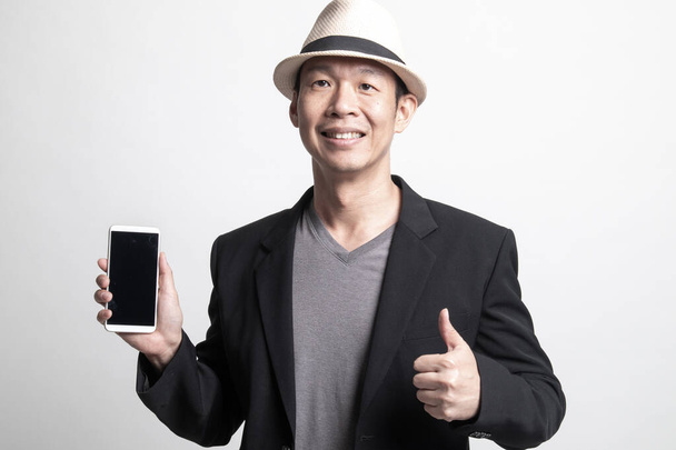 Adult Asian man show thumb up  with mobile phone on white background - Foto, imagen