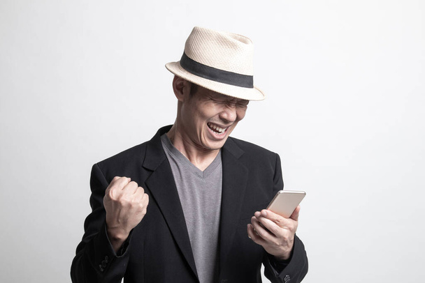 Επιτυχημένος ενήλικας Ασιάτης με κινητό τηλέφωνο σε λευκό φόντο - Φωτογραφία, εικόνα