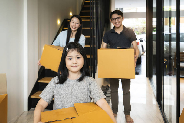 felicidade asiático família mãe pai filha movendo-se em nova casa mão levar caixa de coisas com saída e diversão alegre expressão
 - Foto, Imagem
