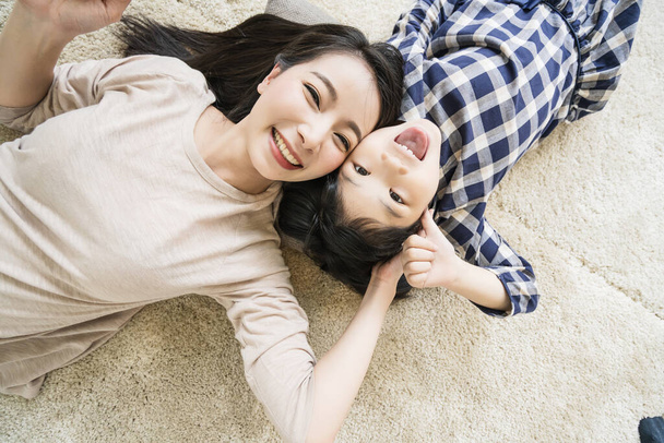 heureux asiatique famille mère et fille faire un selfie photo tandis que l'utilisation dans salon maison fond
. - Photo, image