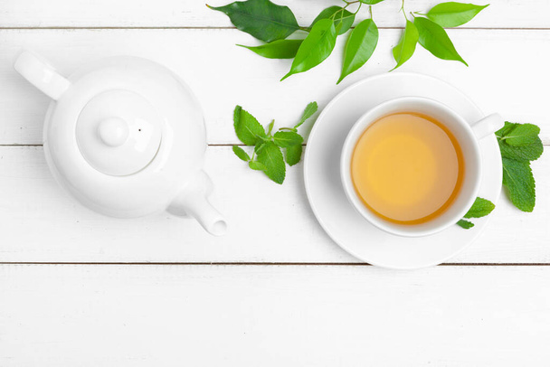 teapot and cups of tea on a white wooden background - Фото, изображение