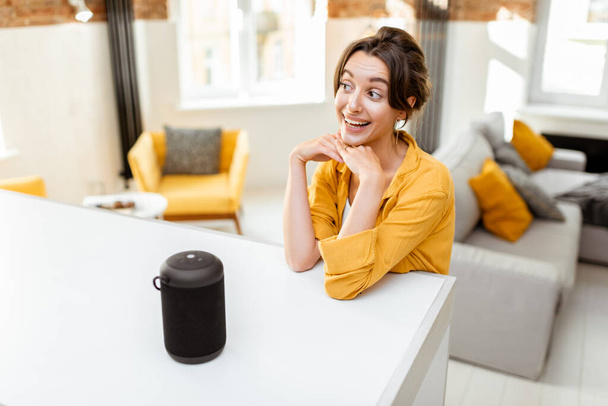 Woman controlling smart home devices with a voice commands - Foto, Imagen