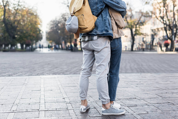 Cropped view of couple hugging with backpack in Europe - Valokuva, kuva