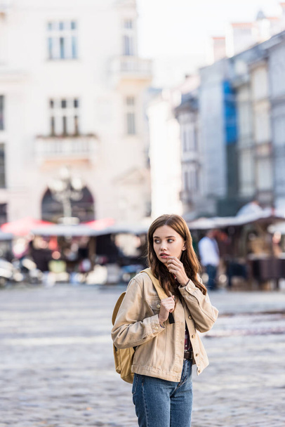 Beautiful woman looking away with backpack in city - Foto, Imagen