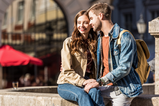 Happy girlfriend and boyfriend sitting together and smiling in city - Fotoğraf, Görsel