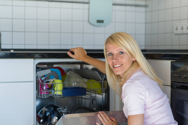 Woman admits a dishwasher - Zdjęcie, obraz