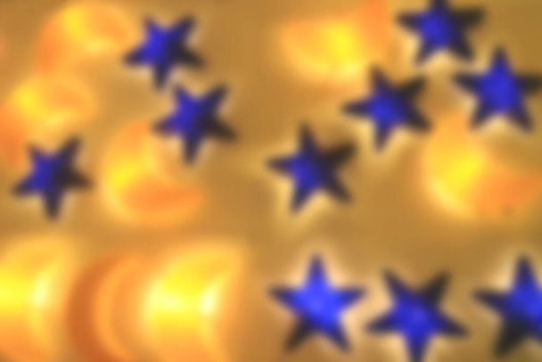 Gelbe Mondsichel und blaue sternförmige Lampen, die an der Wand leuchten - Foto, Bild