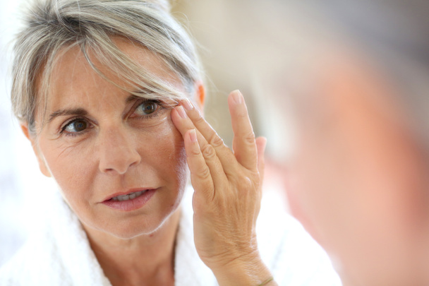 Woman applying anti-wrinkles cream - Photo, Image