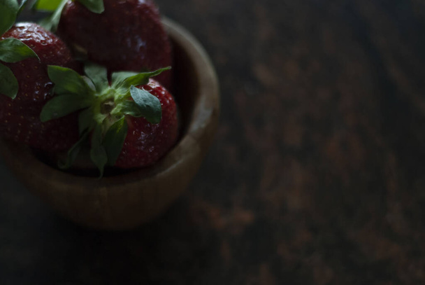 Top view of many fresh strawberries in a wood bowl close up - Foto, immagini