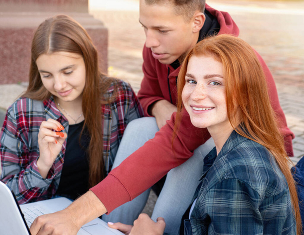 Üniversitenin yakınında açık havada okuyan mutlu bir grup öğrenci. Eğitim kavramı - Fotoğraf, Görsel