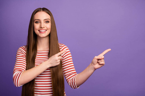 Portrait of positive cheerful girl promoter point index finger copyspace indicate ads promotion recommend suggest select wear jumper isolated over violet color background - Foto, afbeelding