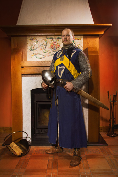 Ridder met zwaard tegen open haard - Foto, afbeelding