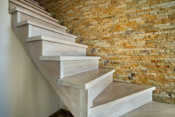 Elegante escalera contemporánea de madera en el interior de la casa loft interior. Pasillo moderno con paredes decorativas de ladrillo caliza y escaleras de roble blanco. - Foto, imagen