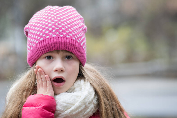 Гарненька дівчинка в теплому в'язаному зимовому одязі на відкритому повітрі
. - Фото, зображення