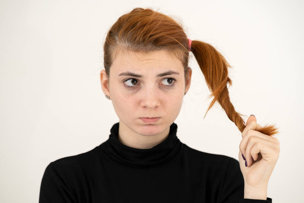 Szoros portré egy szomorú vörös hajú tizenéves lány gyerekes frizura néz sértett elszigetelt fehér háttér. - Fotó, kép