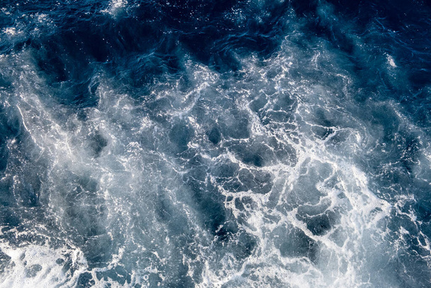 Vista aérea de cima para baixo da superfície da água do mar. Espuma branca ondas textura como fundo natural. - Foto, Imagem