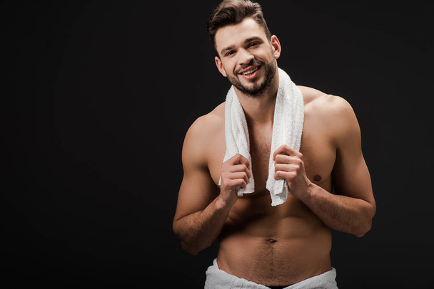 handsome brunette man with towel isolated on black - Foto, afbeelding