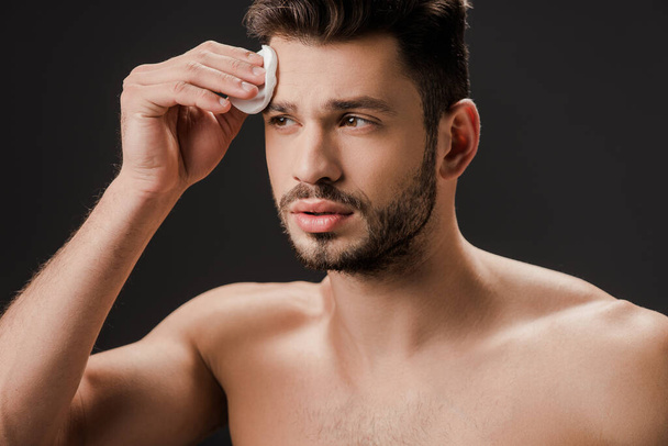sexy naked man using cosmetic cotton pad isolated on grey - Photo, Image