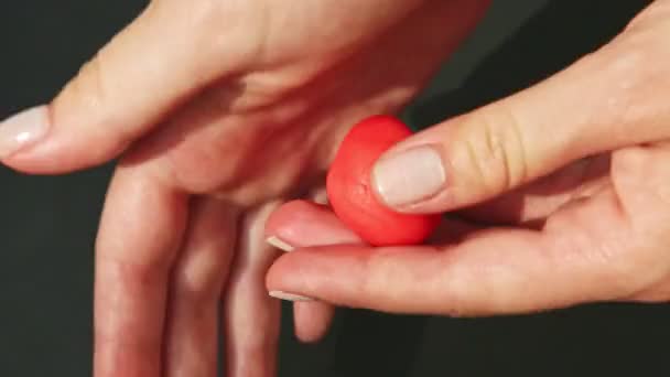 top view on woman hands form strawberry shape from piece of red marzipan mass - Imágenes, Vídeo