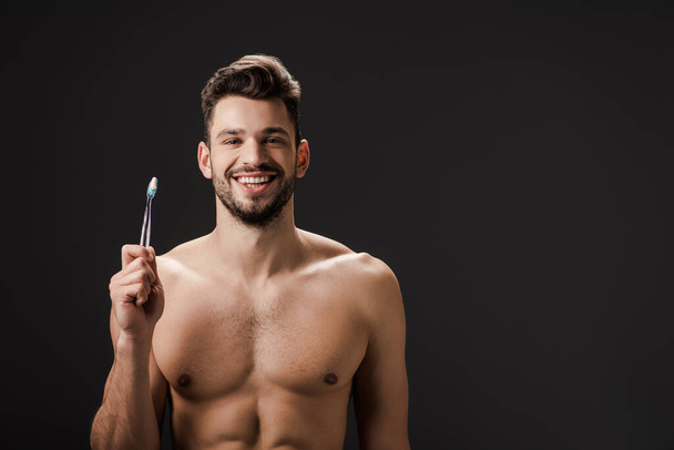 sexy sonriente hombre desnudo con cepillo de dientes aislado en negro
 - Foto, Imagen