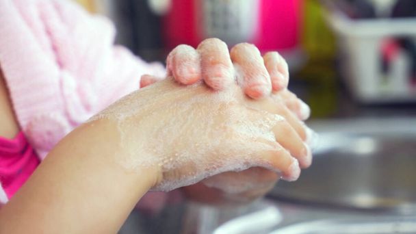 Little girl washing her hands with soap at home, close up - Valokuva, kuva