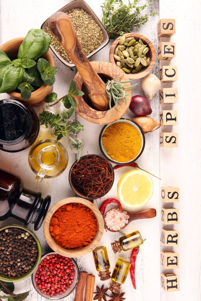 Fűszerek és gyógynövények az asztalon. Élelmiszer és konyha összetevők és fűszerek fűszernövények jel fa kocka az asztalon  - Fotó, kép