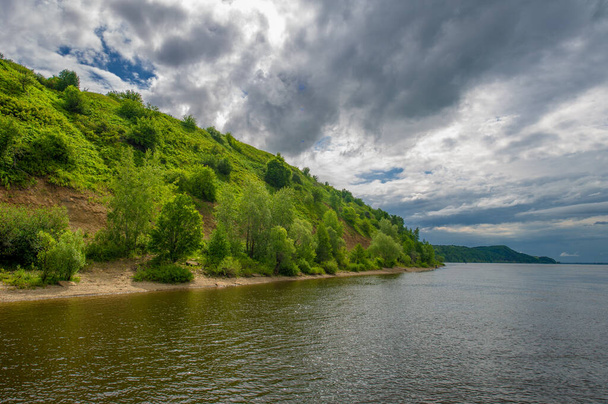foto de verano, potentes nubes de trueno, cielo azul, agua oscura y aguda, paseo turístico a lo largo del río Kama - Foto, imagen
