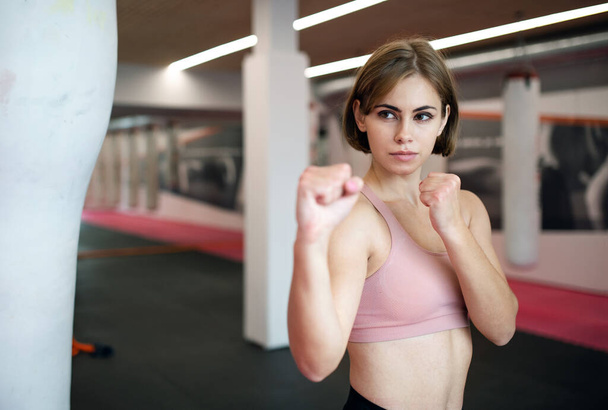 A young woman practising karate indoors in gym. - Photo, Image