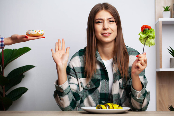Tyttö tekee valinnan terveellisen ja haitallisen ruoan välillä
 - Valokuva, kuva