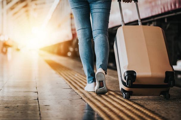 Achteraanzicht van de vrouw reiziger wandelen met bagage op het station. Actief en reizen levensstijl concept - Foto, afbeelding