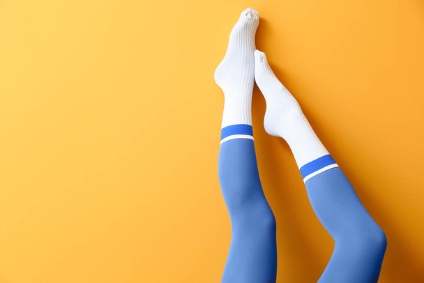 Beine der jungen Frau in Socken und Strumpfhosen auf farbigem Hintergrund - Foto, Bild