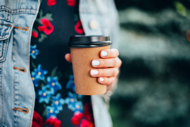 Female hand with paper cup of coffee take away. - 写真・画像
