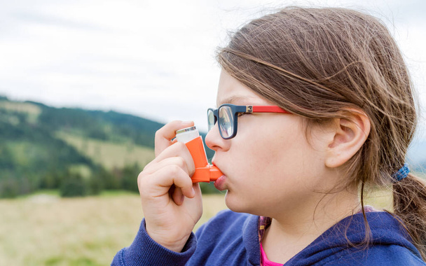 Dívka s astmatem pomocí inhalátoru astmatu venku - mělká hloubka pole - Fotografie, Obrázek