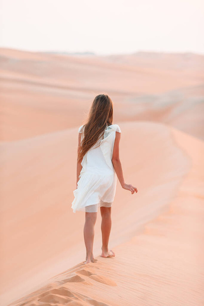 Girl among dunes in desert in United Arab Emirates - Φωτογραφία, εικόνα